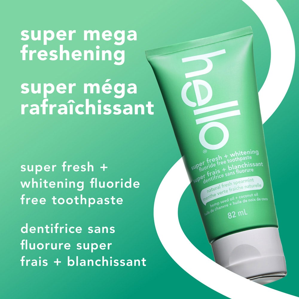 A green tube of hello super fresh + whitening fluoride free toothpaste is angled on a light green background. Above the tube, the text reads, "super mega freshening." To the left, smaller text says, "super fresh + whitening fluoride free toothpaste."