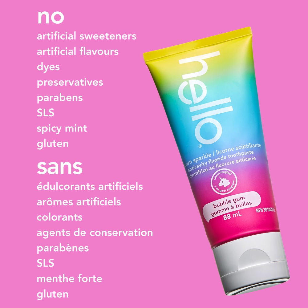A tube of hello unicorn sparkle bubble gum fluoride toothpaste is shown at an angle on a solid pink background. The text beside it highlights, "no artificial sweeteners, artificial flavours, dyes, preservatives, parabens, SLS, spicy mint, gluten."