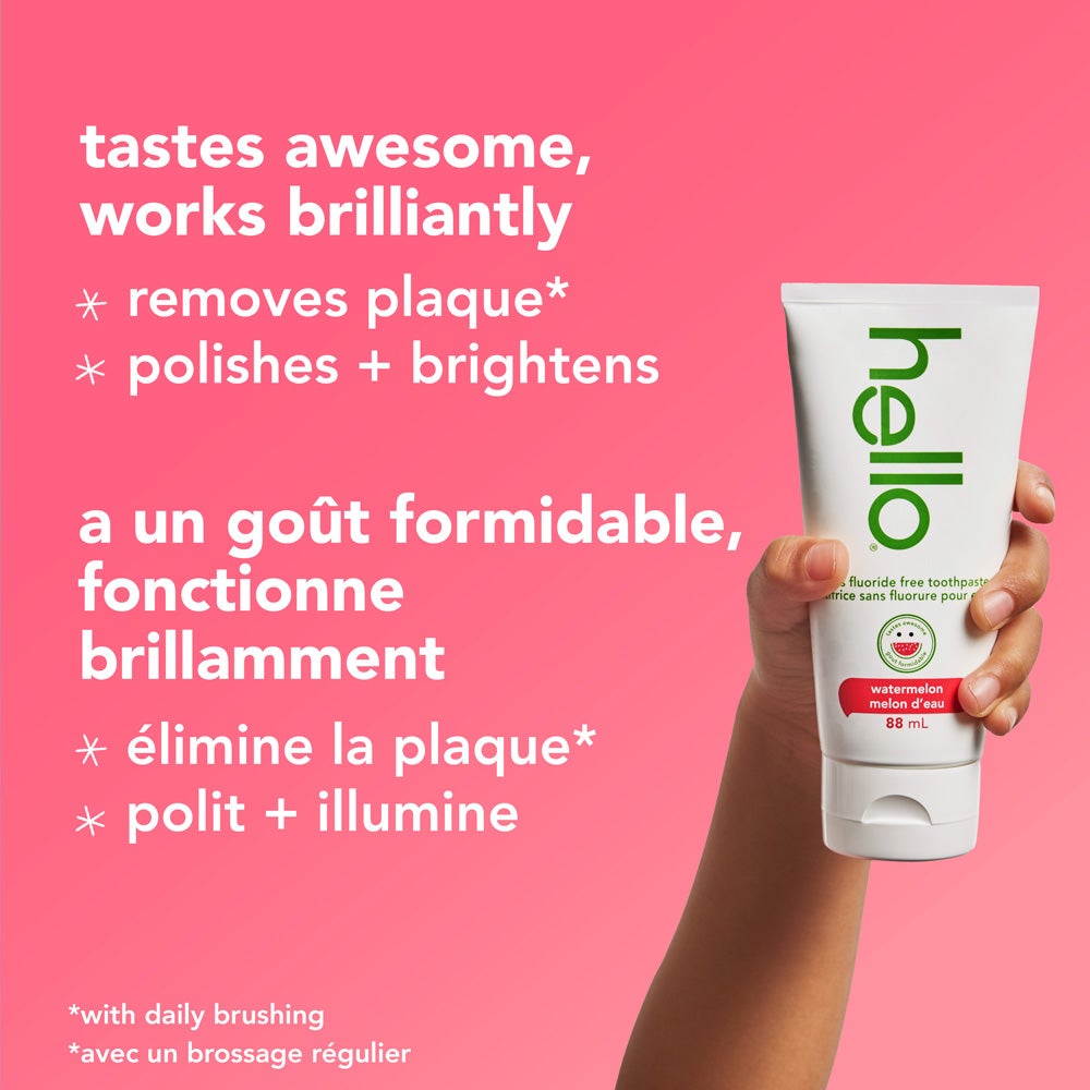 A tube of Hello brand watermelon fluoride-free toothpaste is surrounded by slices of fresh watermelon against a pink background. The text above the product reads, "watermelon fluoride free toothpaste."