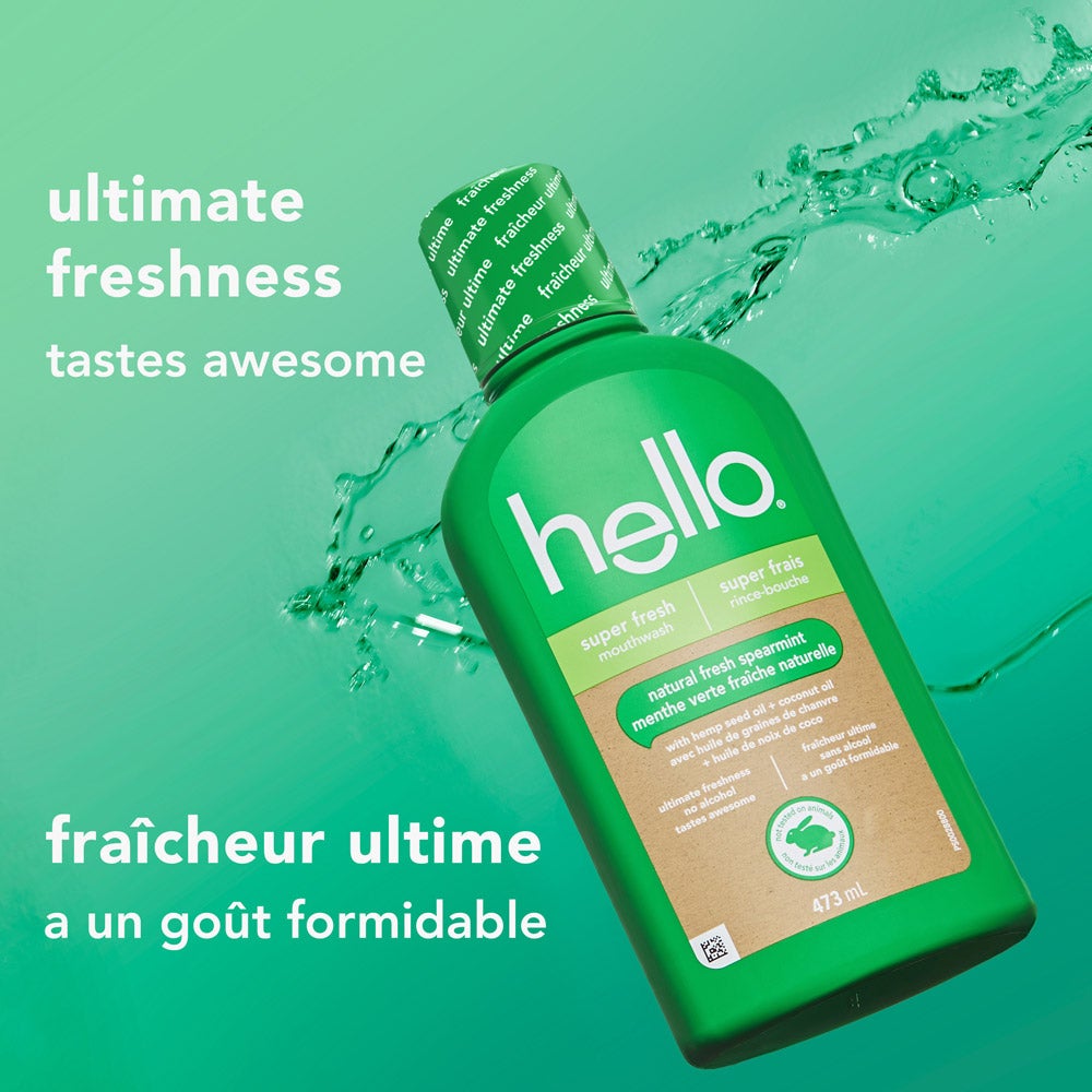 A green hello super fresh mouthwash bottle is displayed in front of a splash of water on a teal gradient background. Text says, "ultimate freshness – tastes awesome" in English and French translation below.