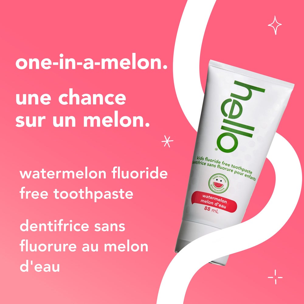 A tube of hello kids watermelon fluoride free toothpaste is set against a pink and white background with curved accents. The text reads, "one-in-a-melon. watermelon fluoride free toothpaste."