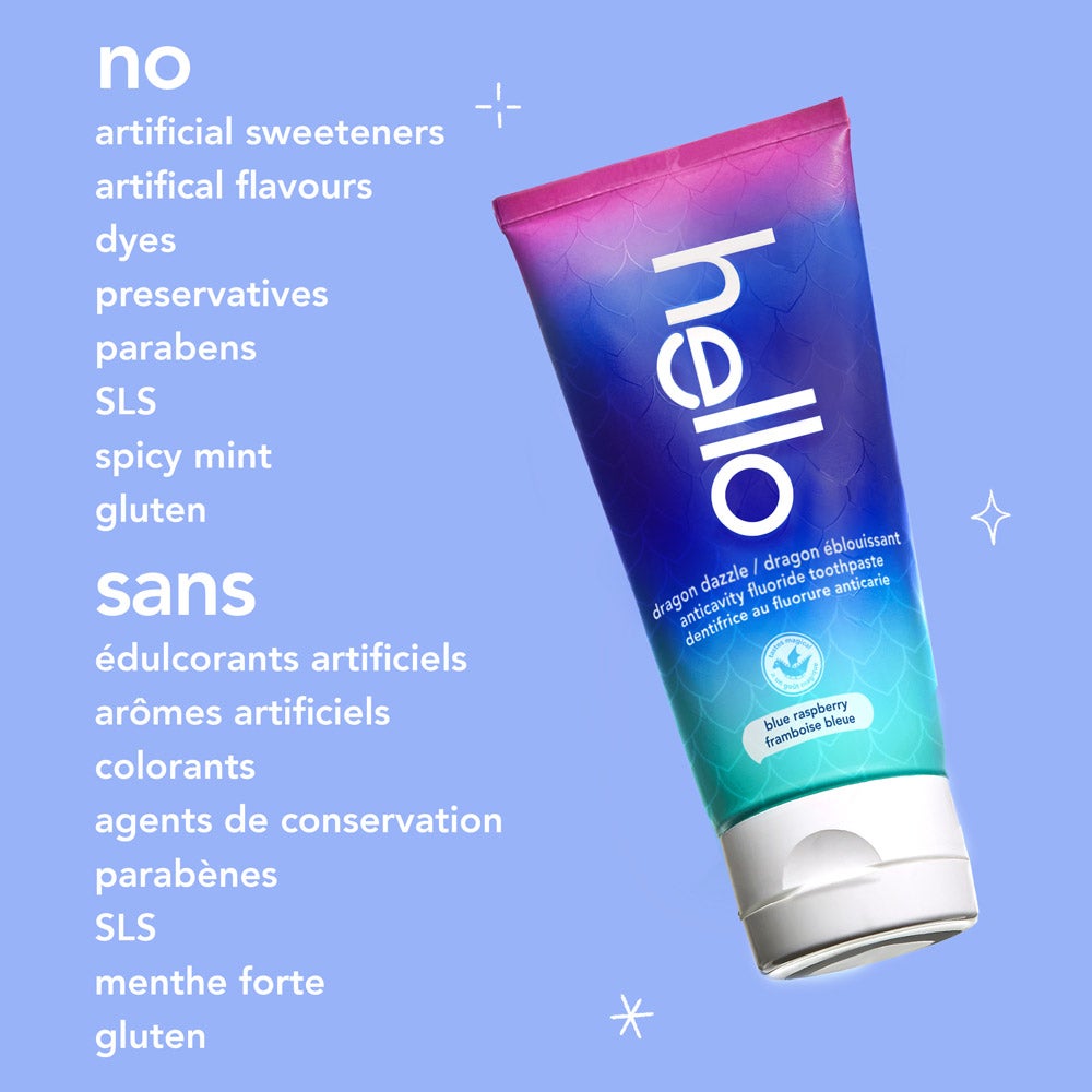 A tilted tube of hello dragon dazzle blue raspberry fluoride toothpaste appears against a pale blue background. The text highlights the absence of certain ingredients: "no artificial sweeteners, artificial flavours, dyes, preservatives, parabens, SLS, spicy mint, gluten."